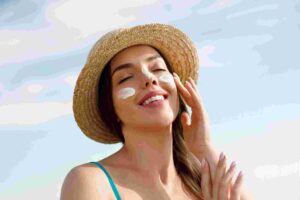 applying sunscreen on face