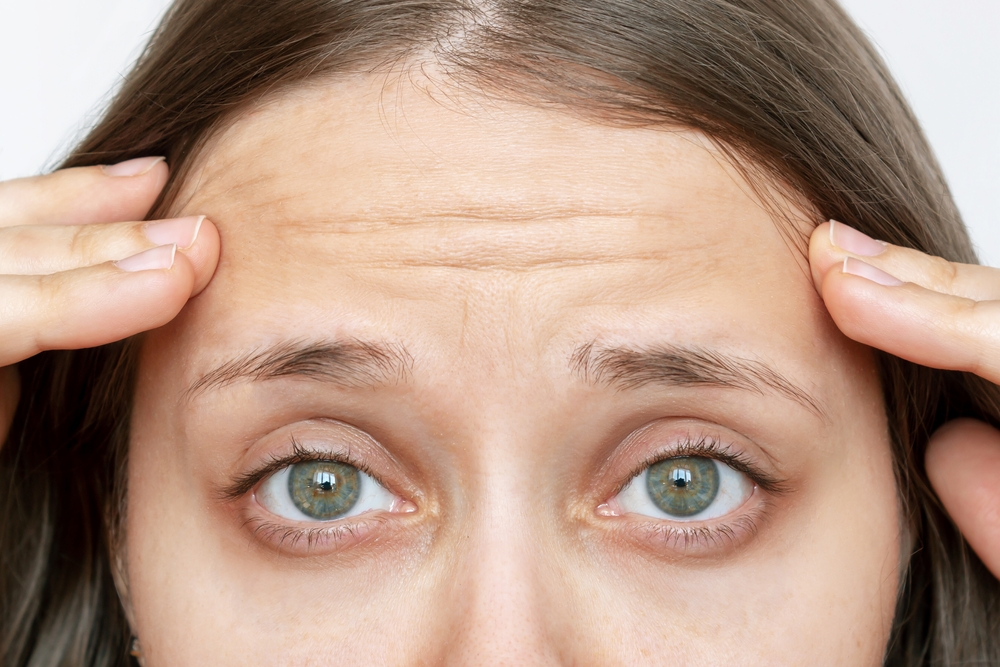 Woman showing concern over forehead wrinkles